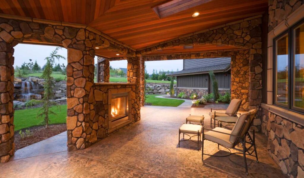 covered stone patio with stone pillars walls and fireplace